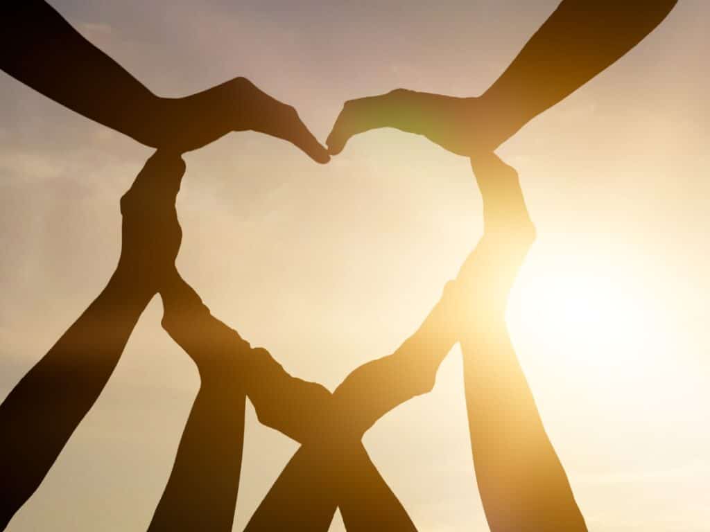 Hands in a circle forming the shape of a heart.